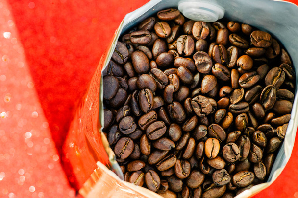 Goldfolie Kaffeebohnensack isoliert auf rotem Hintergrund. Kaffee, Heiterkeit, Aroma - Foto, Bild