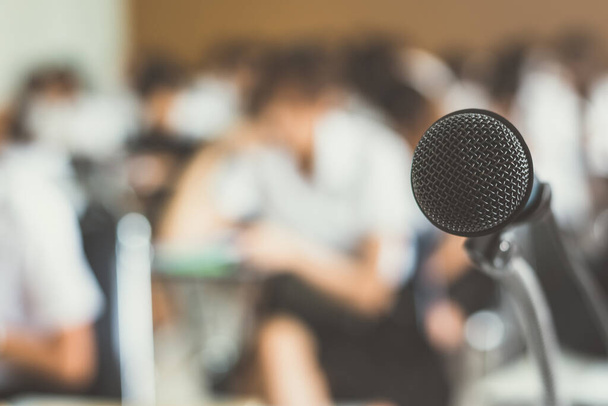 Conférencier vocal au microphone avec public dans une salle de séminaire, une salle de conférence ou une réunion de conférence dans un événement éducatif pour animateur, enseignant ou mentor  - Photo, image
