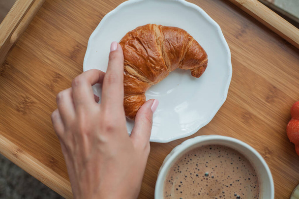 Female hands, mug of hot cocoa, pumpkin, croissant - Fotó, kép