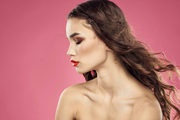 Beautiful woman with red lips on a pink background nude shoulders cropped view - Photo, Image