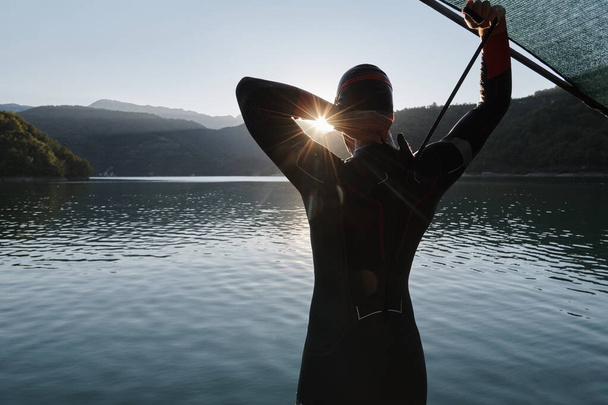 αθλητής τριάθλου που αρχίζει προπόνηση κολύμβησης στη λίμνη - Φωτογραφία, εικόνα