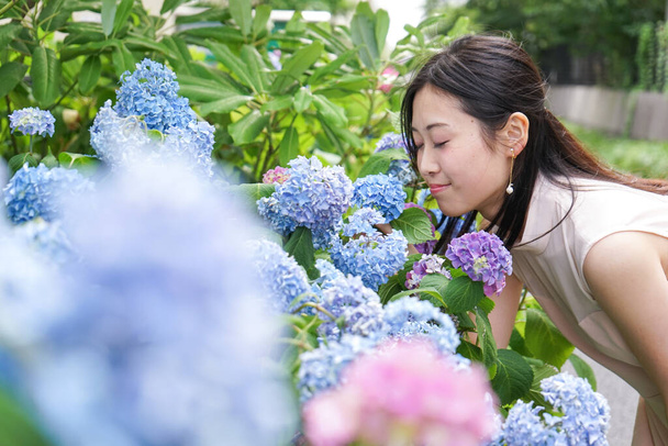 Fiatal nő pózol közel virágok - Fotó, kép