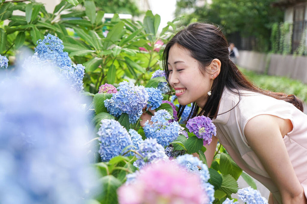 Young woman posing near flowers - Φωτογραφία, εικόνα