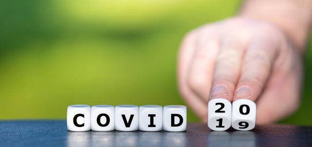 次のウイルスパンデミックのシンボル。手はサイコロを回し、式「 covid 19 」を「 covid 20 」に変更します。". - 写真・画像