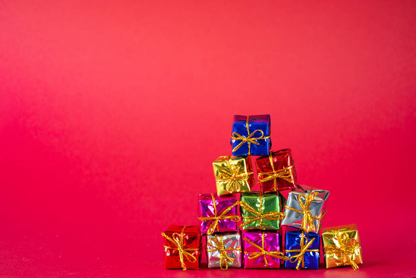 Multicolored bright holiday gift boxes on a red background. Copy space. - Φωτογραφία, εικόνα