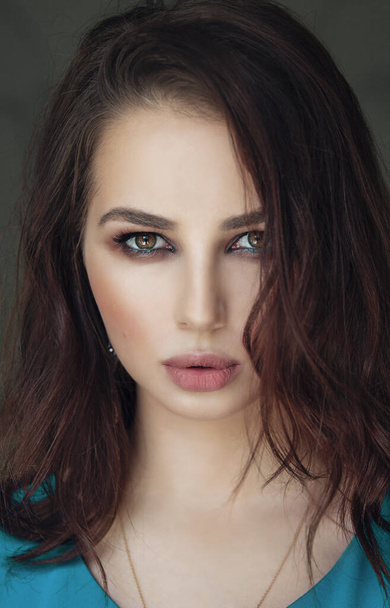 portrait of a woman with dark hair and makeup on her face - Фото, зображення