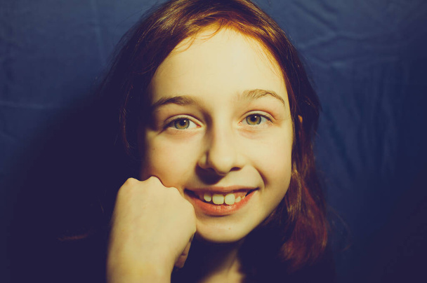 Portret van een 10-jarig meisje met een blauwe achtergrond. Tiener meisje 9 of 10 jaar oud - Foto, afbeelding