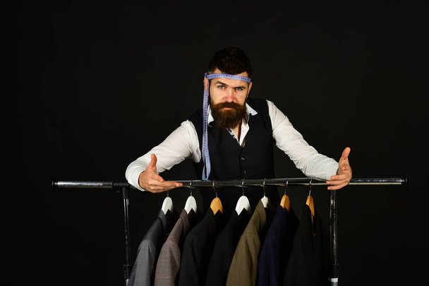 Stylish man in clothing boutique on black background - 写真・画像
