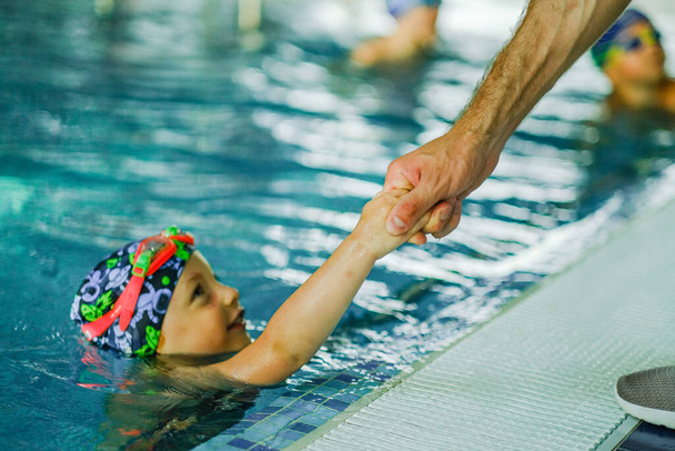 Treinamento de natação infantil na piscina. Treino de natação para uma criança. Desenvolvimento de esportes infantis. Fortalecimento da saúde do bebê. - Foto, Imagem