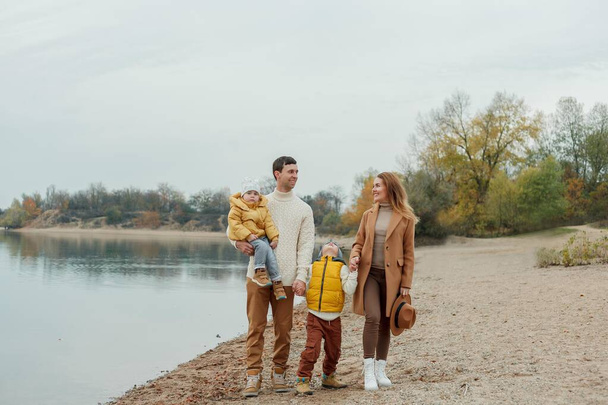 湖の近くを歩いている子供たちと一緒に美しい幸せな家族 - 写真・画像