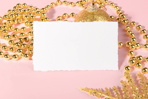 Різдвяна листівка макет з золотим святковим прикрасою на рожевому пастельному фоні. Елемент дизайну на Різдво та Новий рік вітання, рсвп, дякую, вітальна листівка або запрошення
 - Фото, зображення