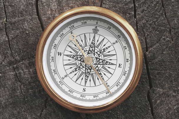 Rundkompass auf natürlichem Holzgrund als Symbol des Tourismus mit Kompass, Reisen mit Kompass und Outdoor-Aktivitäten mit Kompass - Foto, Bild