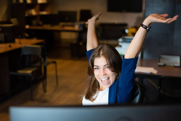 Joyful woman at her desk in the office - Fotó, kép