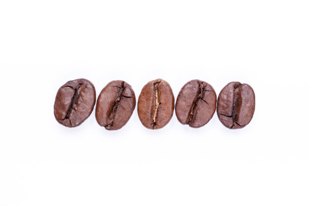 Minus sign made of coffee beans on a white background. Coffee beans isolated on white. Macro. - Zdjęcie, obraz