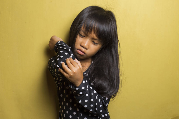 Asiática niña teniendo dolor en lesionado codo. - Foto, imagen