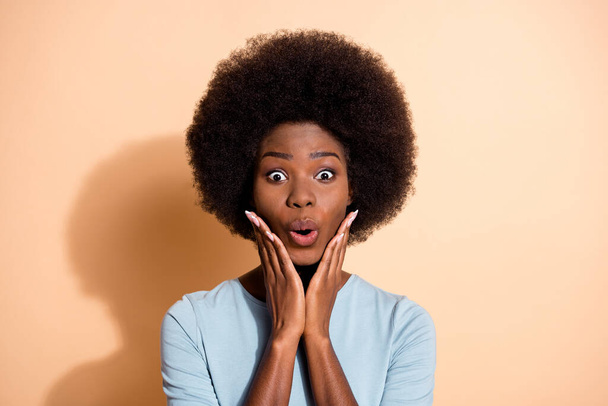 Photo portrait of excited african american woman touching face with hands isolated on pastel beige colored background - Photo, Image