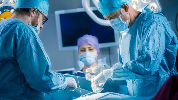 In the Hospital Operating Room Diverse Team of Professional Surgeons and Nurses Suture Wound after Successful Surgery. - Photo, Image
