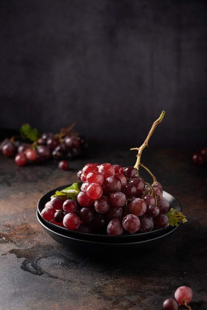 Concept of healthy vegn food. Red grapes on the black table, selective focus image - Fotografie, Obrázek