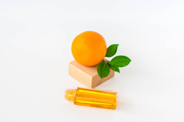 Orange oil for the body. Orange on a white background. Organic SPA cosmetics with herbal ingredients. Cosmetology.   - Фото, изображение