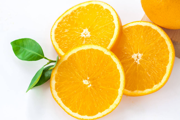 Cut orange on a white background. Natural orange fruit with cut slices. Vitamin C. Healthy citrus fruit.   - Photo, image