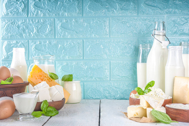 Set di vari latticini freschi latte, ricotta, formaggio, uova, yogurt, panna acida, burro su sfondo di legno - Foto, immagini