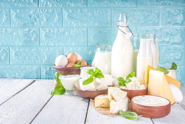 Erilaisia tuoreita maitotuotteita maito, raejuusto, juusto, munat, jogurtti, smetana, voi puupohjalla - Valokuva, kuva