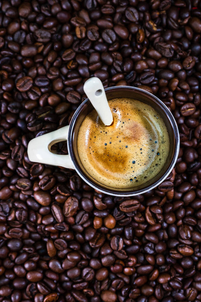 Κύπελλο καφέ με καβουρδισμένους κόκκους καφέ σε κόκκινο φόντο, έννοια του καφέ, close up φωτογραφία καφέ - Φωτογραφία, εικόνα