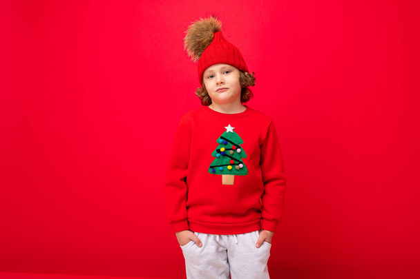 emotional portrait of a teenager on a red background in a new year costume - Foto, Imagem