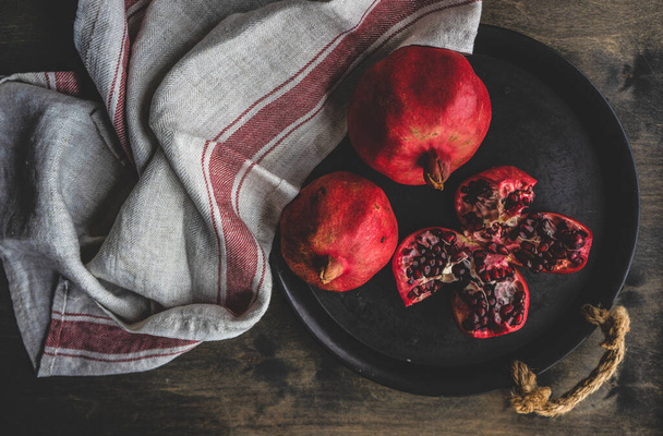 Organické granátové jablko s jeho semeny na talíři jako koncepce organických potravin - Fotografie, Obrázek