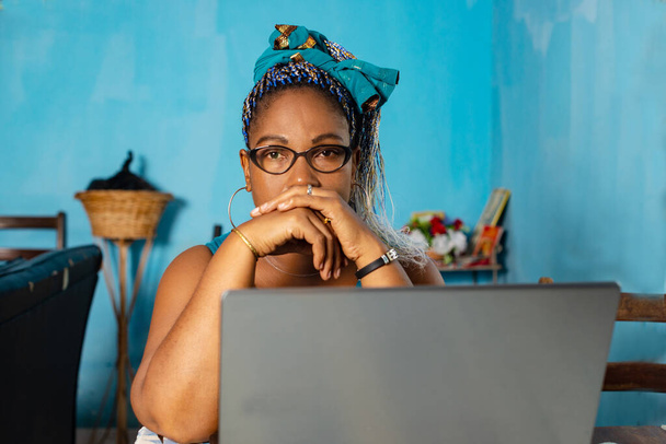 mulher madura em óculos sentado no salão com laptop assistindo a câmera. - Foto, Imagem