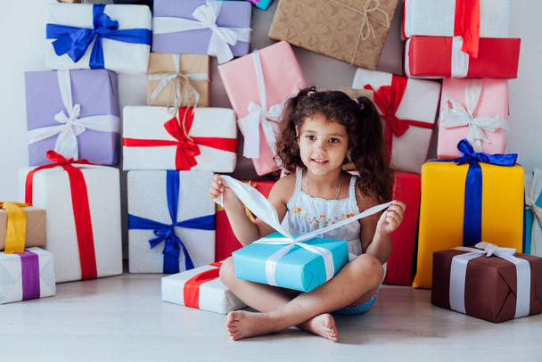 Beautiful little curly girl with gifts for birthday party - Фото, изображение