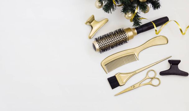 Banner con herramientas de peluquería en color oro y un árbol de Navidad sobre un fondo blanco. Plantilla de vacaciones con accesorios de peluquería. - Foto, imagen