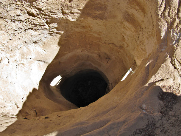 Desert water well with rope ladder. Round pit in the sandstone in the oasis - Photo, Image