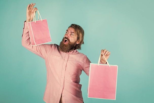 Quality service. paper shopping bag. birthday surprise at party. man with package. prepare for holidays. best sale offer. happy bearded man with present pack. cheerful brutal hipster hold gift - Foto, imagen