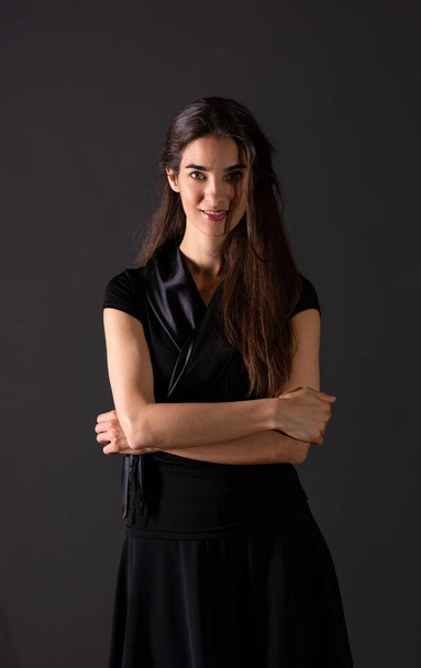 A smiling young woman standing in the studio - Fotografie, Obrázek