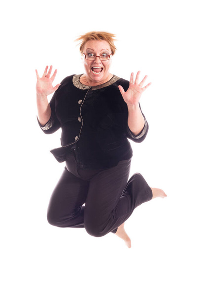 Middle aged woman in black jacket and trousers jumping - Foto, immagini