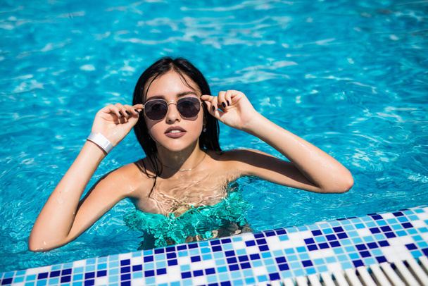 Beautiful young woman in bikini at a pool - Valokuva, kuva