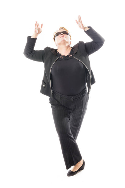 Mujer de mediana edad en chaqueta negra y pantalones bailando un baile emocional - Foto, imagen