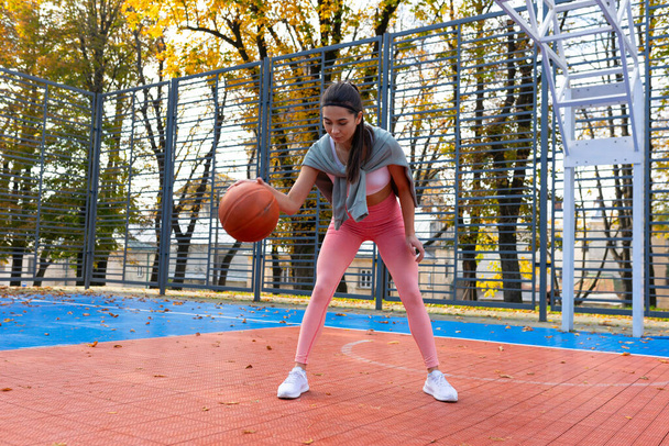 Dziewczyna grać z piłką na boisku do koszykówki - Zdjęcie, obraz