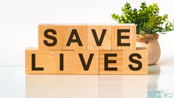 SAVE LIVES Wort auf Holzblock geschrieben. Suchmaschinenoptimierung, Faqs Text auf dem Tisch, medizinisches Konzept - Foto, Bild