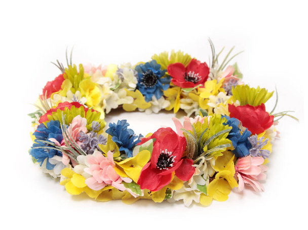 A round wreath with colorful flowers on a white surface - Foto, imagen