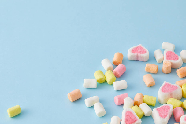 A top view closeup of colorful marshmallows isolated on a blue background - Fotó, kép