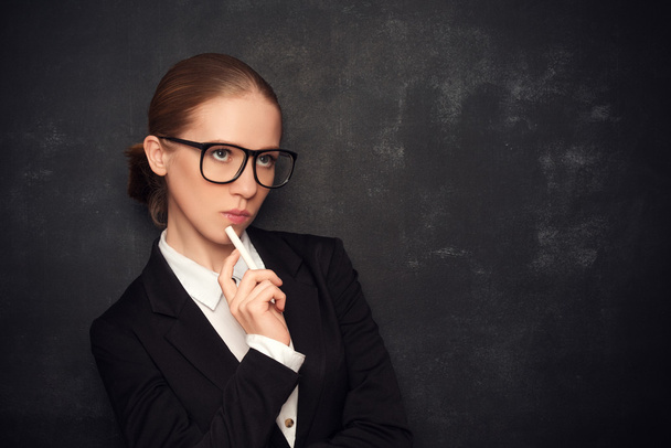 бизнес-учительница в очках и костюм с мелом в
 - Фото, изображение