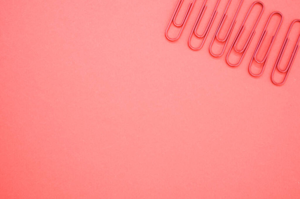 Μια κοντινή φωτογραφία πολύχρωμων συνδετήρων σε ένα κομμάτι χαρτί. - Φωτογραφία, εικόνα