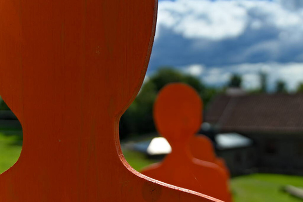 Оранжевые деревянные силуэты людей, стоящих в очереди. - Фото, изображение