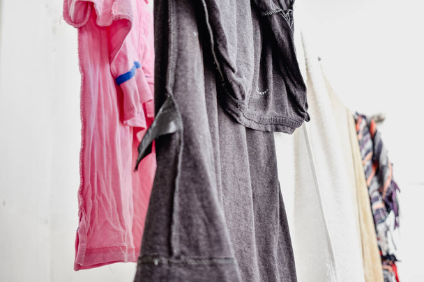 Elbiseler çamaşır ipinde asılı ve kuruması için giyinmiş. - Fotoğraf, Görsel