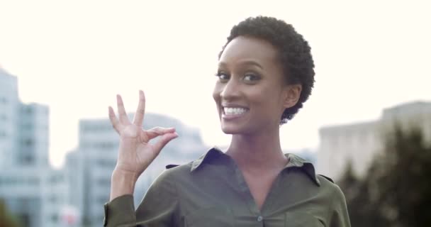 Portret van actief gelukkig Afrikaans meisje staat te poseren voor de camera glimlachend met witte tanden voelt tevredenheid, steekt de hand op, toont een goed gebaar, vouwt vingers tot nul, symbool van instemming overwinning - Video