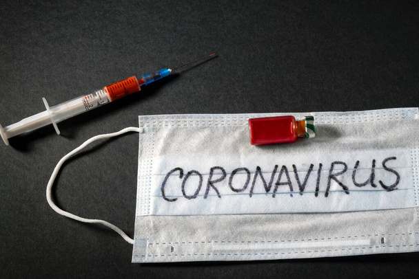 positive analysis of the Chinese epidemic against the background of a protective mask for a syringe, a vaccine. coronavirus from wuhan province of china. deadly epidemic nCOV - 2020 on a black background. - Φωτογραφία, εικόνα