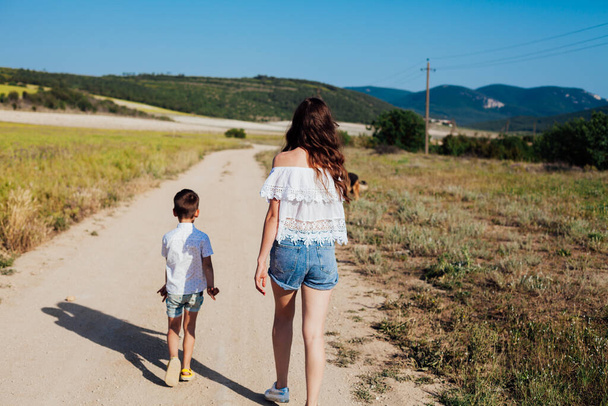 Máma a syn procházka po venkovské silnici v poli - Fotografie, Obrázek