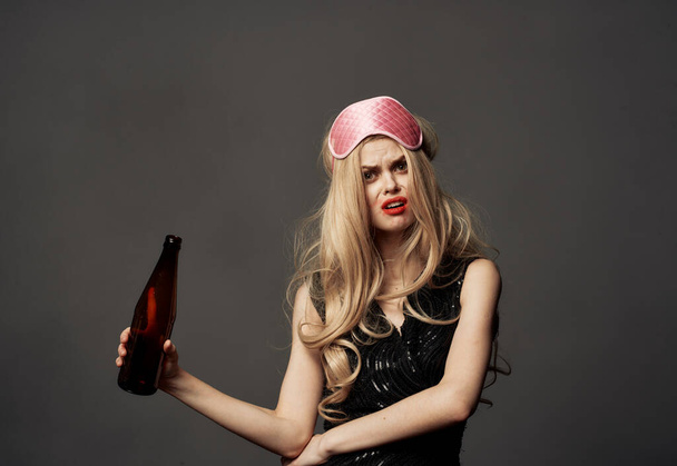 美しいですブロンドとともにビールボトルで彼女の手とピンクマスク上の彼女の頭 - 写真・画像